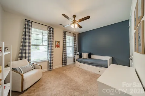 a bedroom with a large bed couch and a window