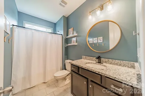 a bathroom with a granite countertop sink a mirror and a shower