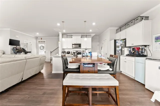 a room with stainless steel appliances kitchen island granite countertop a dining table chairs and view kitchen