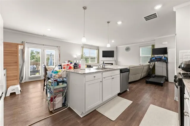 a kitchen that has a lot of cabinets a sink and appliances in it