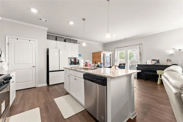 a kitchen with a sink a counter top space stainless steel appliances and cabinets