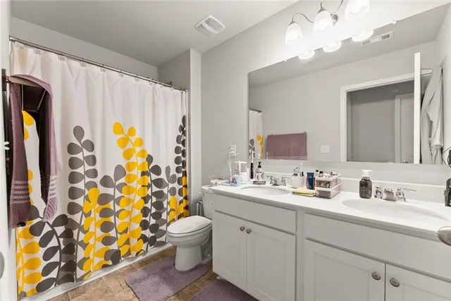 a bathroom with a double vanity sink mirror and shower