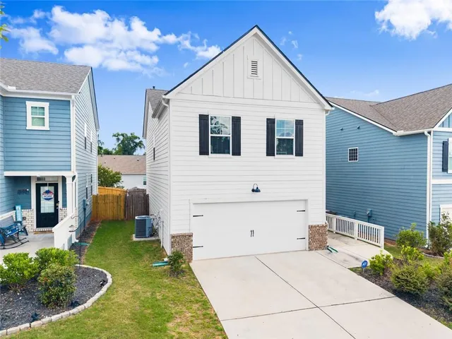 a view of a white house with yard and windows