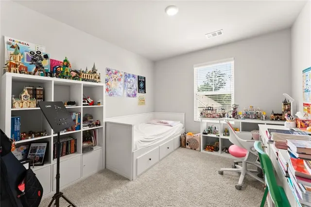 a room with furniture a air conditioner vent and a window