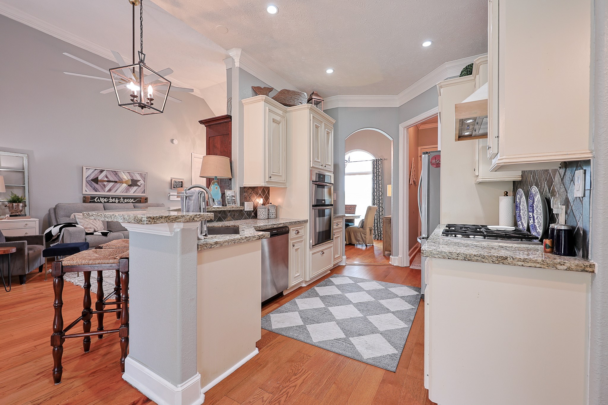 4704 Donald Street Seabrook, TX 77586 - Photo 18 of 42 a kitchen with stainless steel appliances granite countertop a stove a sink a refrigerator and white cabinets with wooden floor