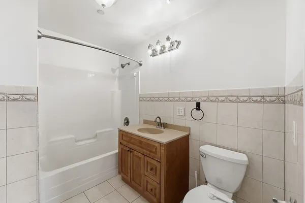 a bathroom with a granite countertop sink mirror toilet and bathtub