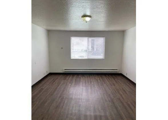 a view of a room with wooden floor and a window