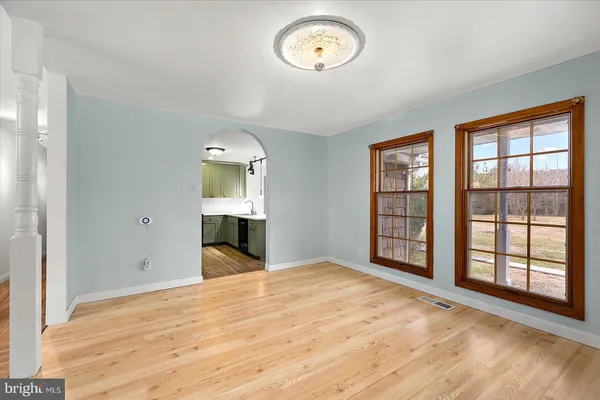 a bed sitting in a spacious bedroom next to a window