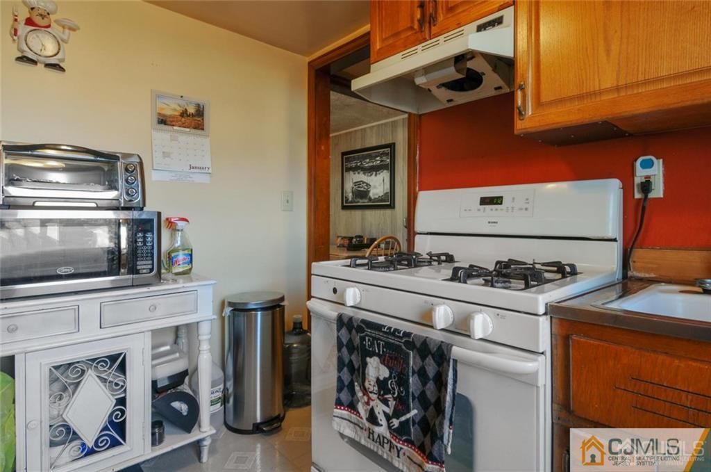136 McFarlane Road Colonia, NJ 07067 - Photo 12 of 23 a kitchen with stainless steel appliances granite countertop a stove and a microwave
