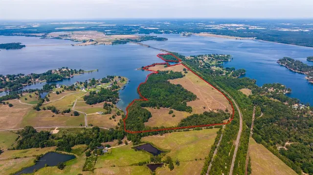 an aerial view of lake and residential houses with outdoor space