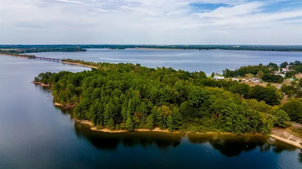 a view of a lake with lawn chairs and a fountain