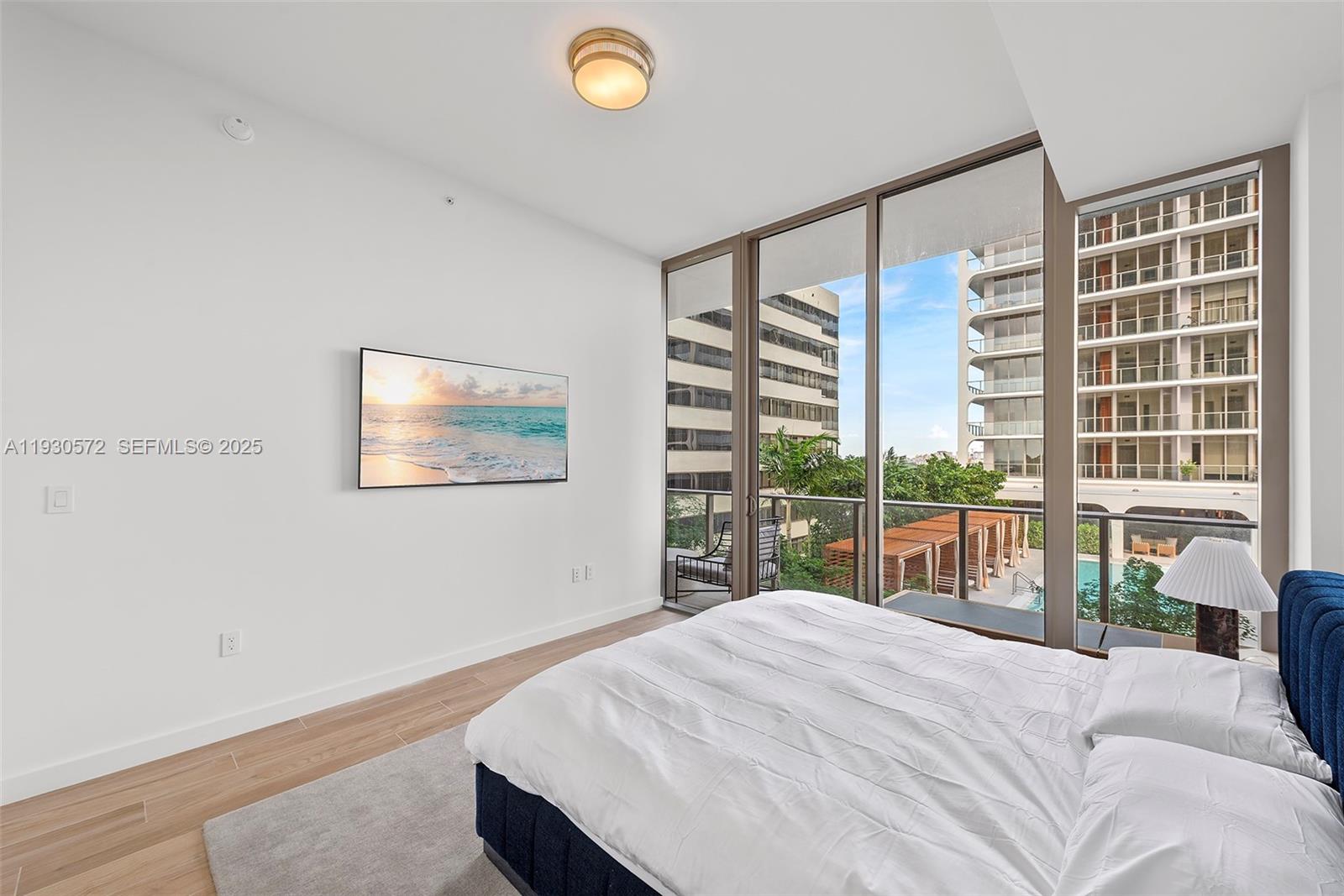 2655 South Bayshore Drive, Unit 909 Miami, FL 33133 - Photo 17 of 26 a bedroom with a large bed and a large window