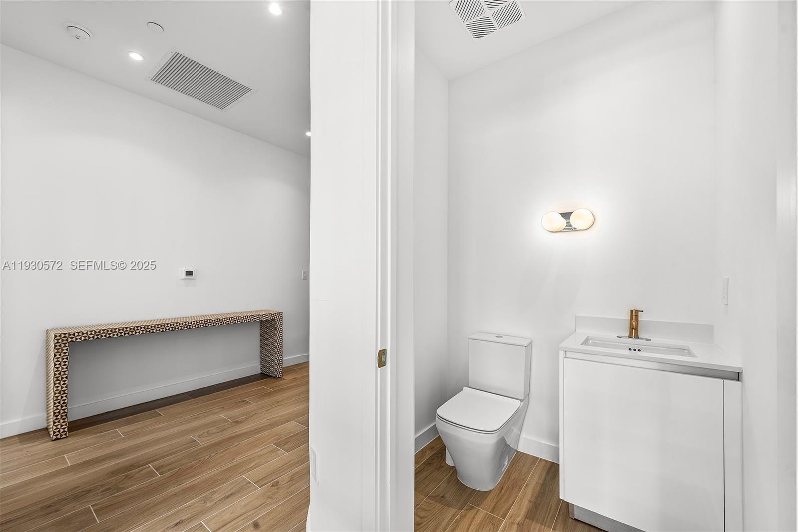 2655 South Bayshore Drive, Unit 909 Miami, FL 33133 - Photo 22 of 26 a bathroom with a toilet and a sink