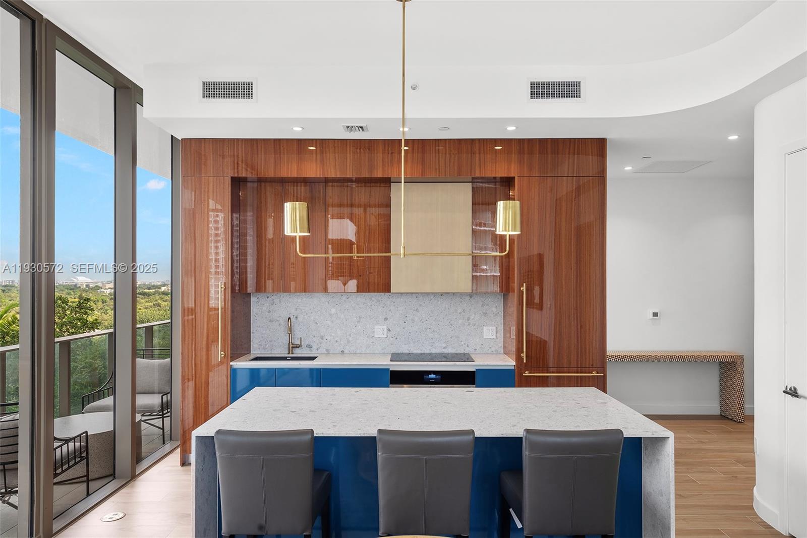 2655 South Bayshore Drive, Unit 909 Miami, FL 33133 - Photo 4 of 26 a kitchen with a refrigerator a sink and cabinets