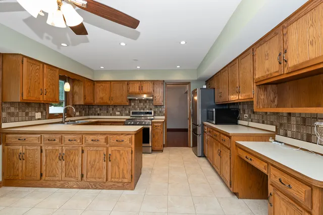 a large kitchen with stainless steel appliances kitchen island granite countertop a sink and cabinets
