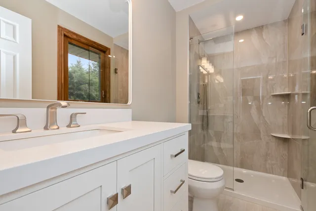 a bathroom with a sink a toilet and shower