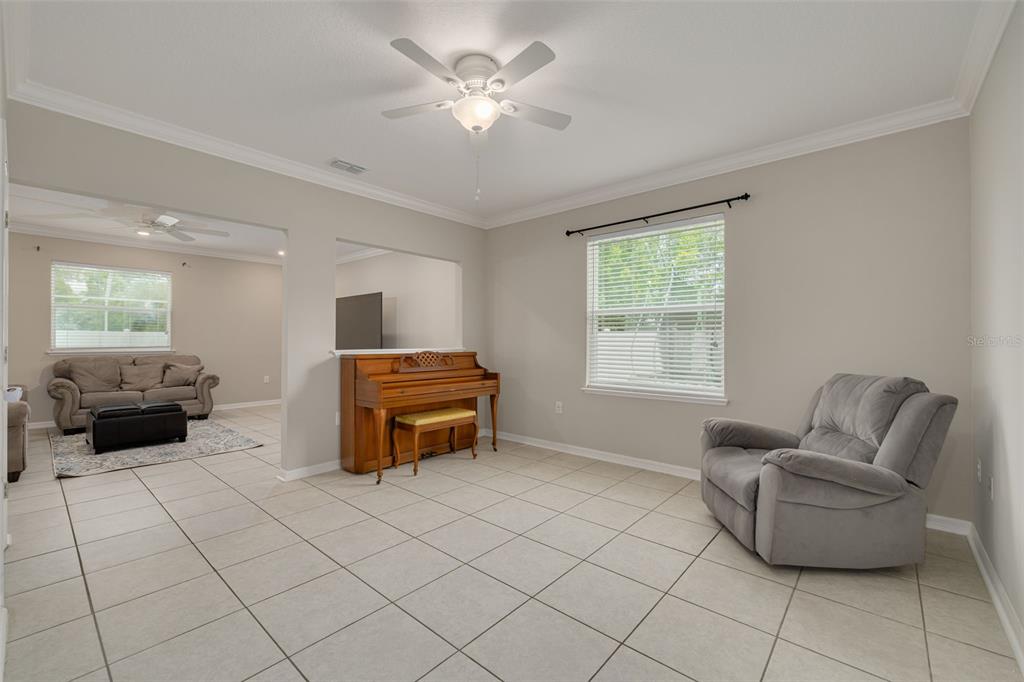 7242 Landmark Drive Spring Hill, FL 34606 - Photo 15 of 45 a living room with furniture and a chandelier