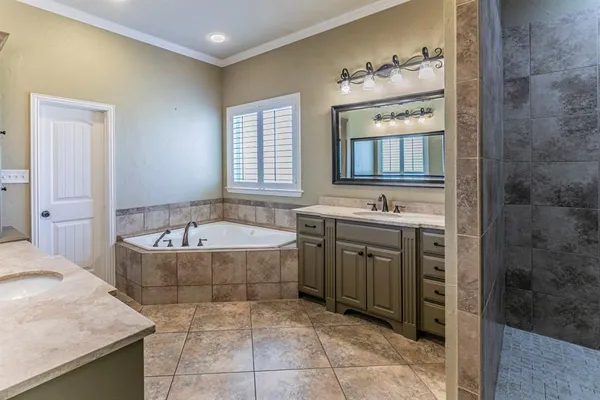 a spacious bathroom with a tub sink and mirror