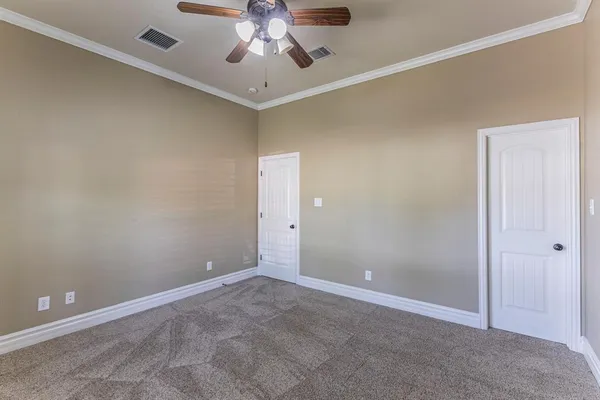 an empty room with a fan and a chandelier fan