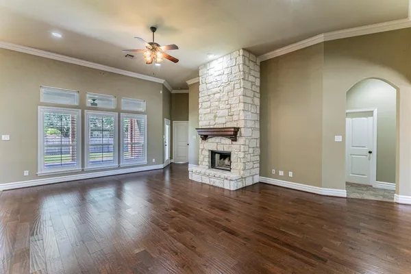 a view of a livingroom with wooden floor a fireplace and windows