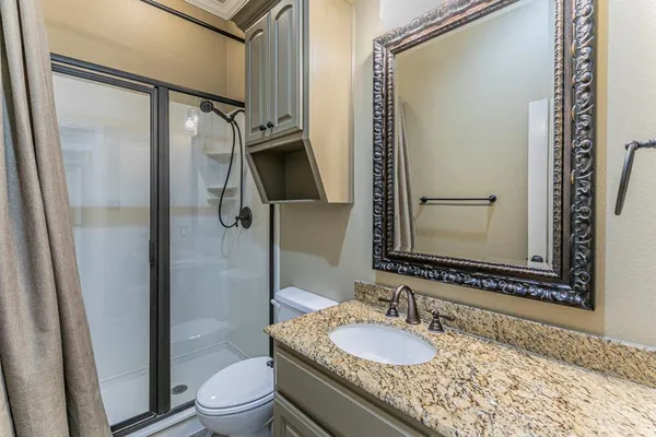 a bathroom with a granite countertop sink toilet and shower