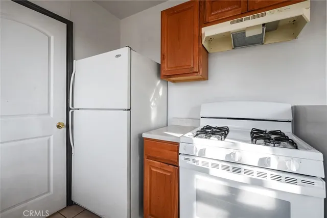 a white refrigerator freezer and a stove sitting inside of a kitchen