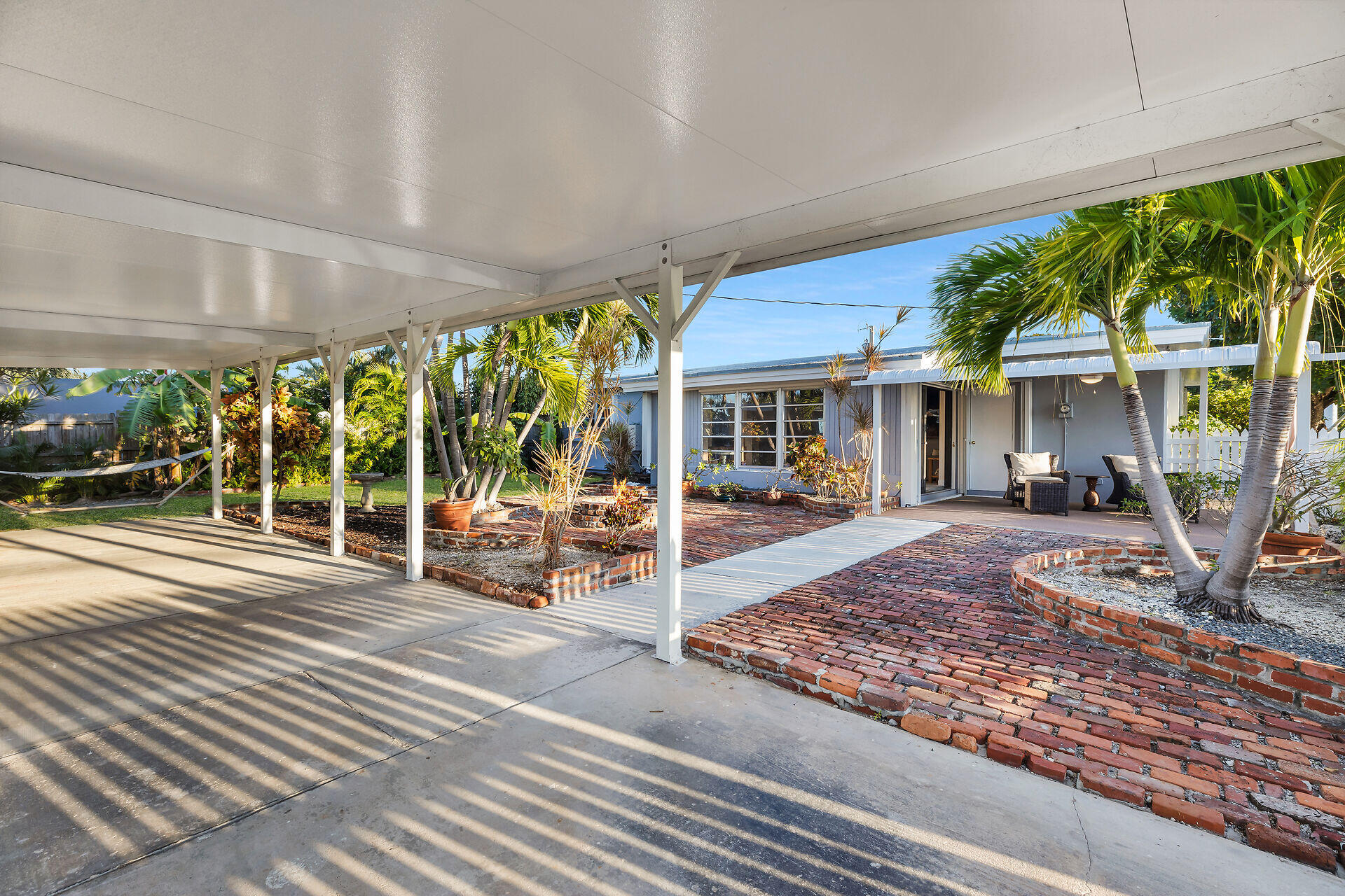 2801 Fogarty Avenue Key West, FL 33040 - Photo 16 of 53 a view of a patio with table and chairs under an umbrella next to a yard