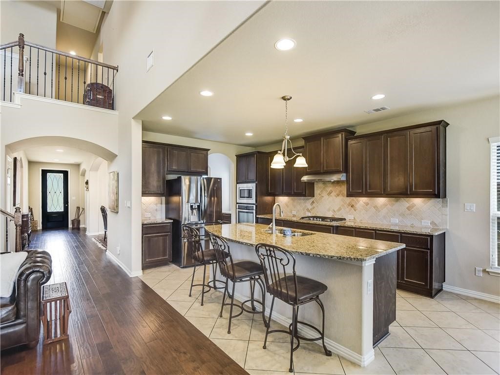 137 Nantucket Circle Austin, TX 78737 - Photo 9 of 34 a kitchen with stainless steel appliances granite countertop table chairs sink and cabinets