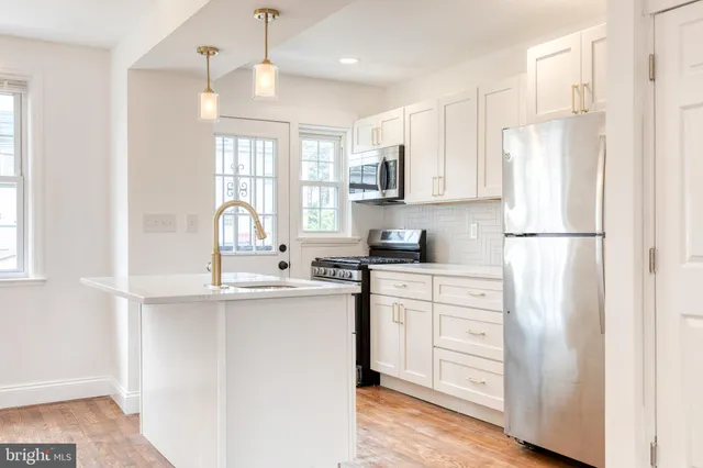a kitchen with white cabinets and white appliances