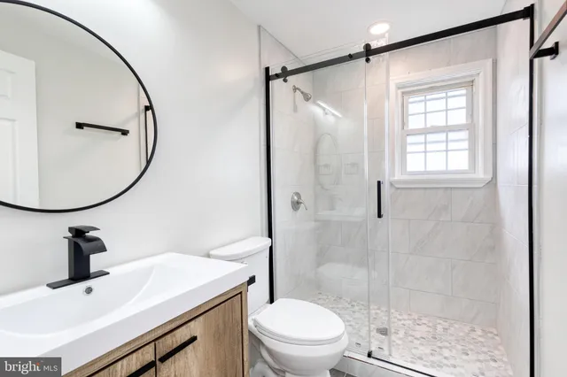 a bathroom with a sink toilet a mirror and shower
