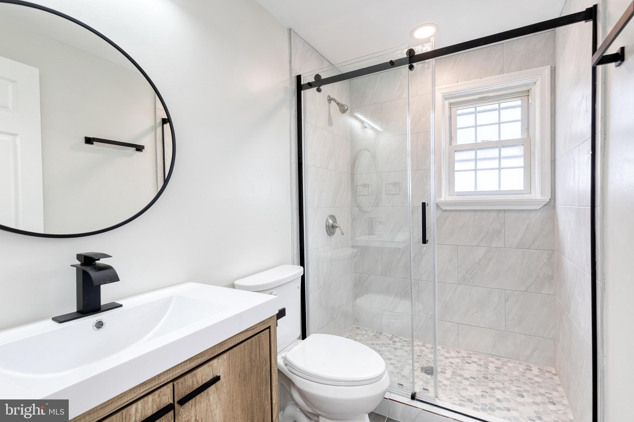 2708 Uhler Avenue Baltimore, MD 21215 - Photo 12 of 18 a bathroom with a sink toilet a mirror and shower