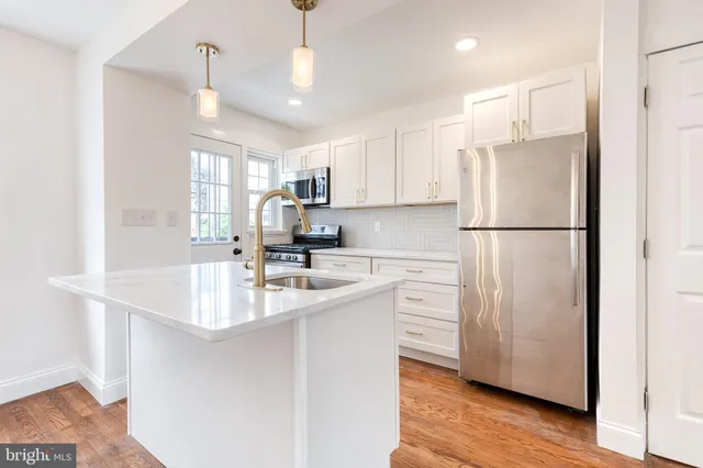 a kitchen with white cabinets and white appliances