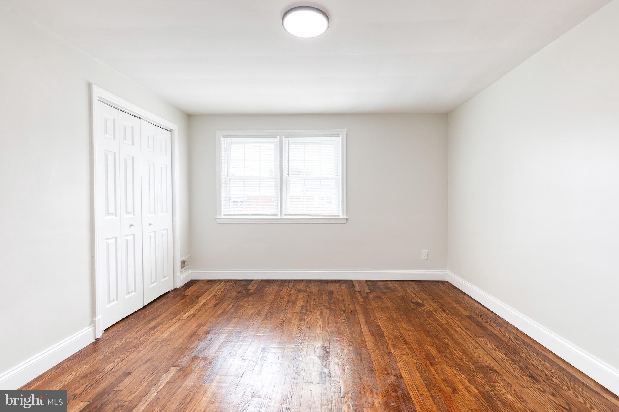 2708 Uhler Avenue Baltimore, MD 21215 - Photo 10 of 18 an empty room with wooden floor and windows