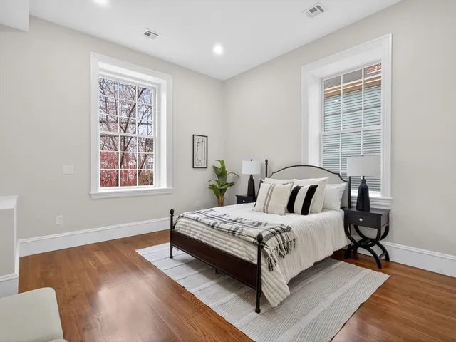 a bedroom with a bed wooden floor and window
