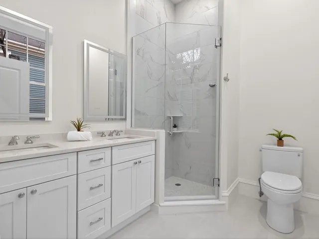 a bathroom with a shower sink vanity and toilet
