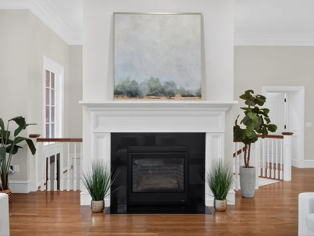 a living room with a fireplace and wooden floor