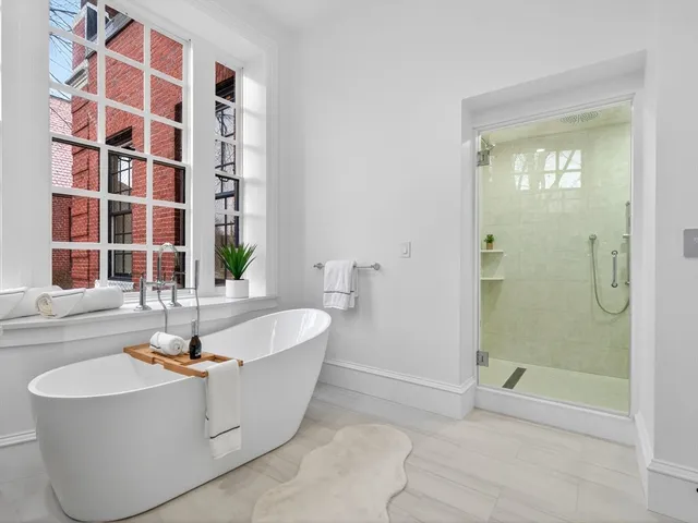 a white bath tub sitting in a bathroom next to a window