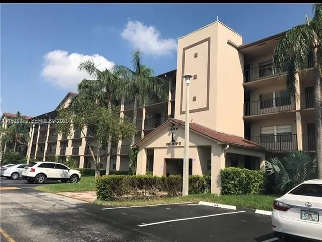 a view of a white building among the street with palm trees