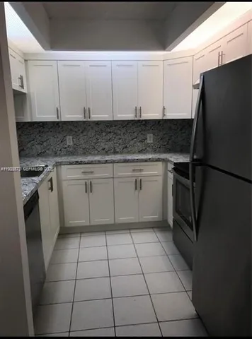 a kitchen with a sink a stove top oven and cabinets