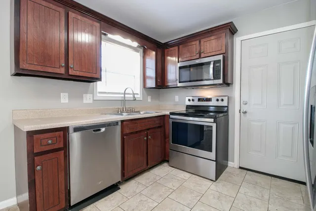 a kitchen with stainless steel appliances granite countertop a stove microwave and sink