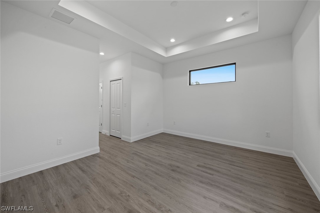 367 Ranier Avenue Lehigh Acres, FL 33974 - Photo 11 of 24 an empty room with wooden floor and windows