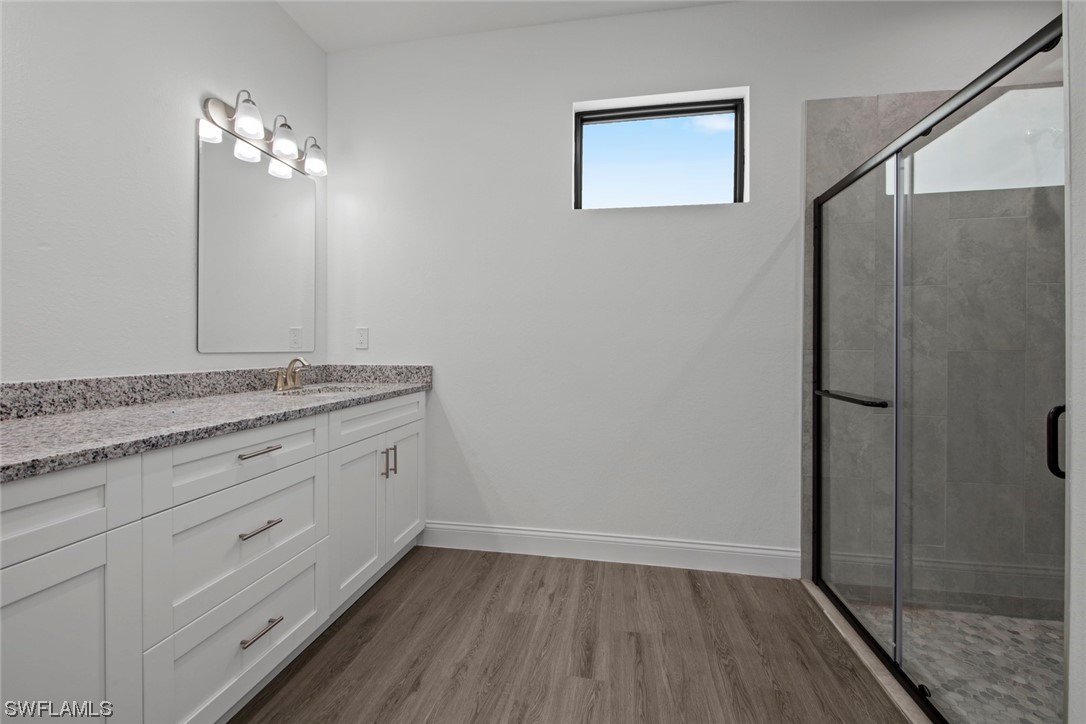 367 Ranier Avenue Lehigh Acres, FL 33974 - Photo 13 of 24 a bathroom with a granite countertop sink a mirror and shower