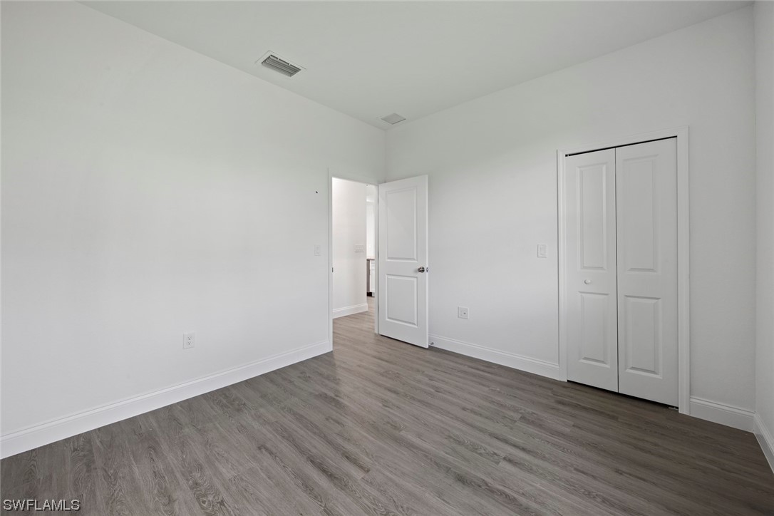 367 Ranier Avenue Lehigh Acres, FL 33974 - Photo 20 of 24 a view of an empty room with wooden floor