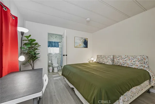 a bedroom with a bed and a potted plant