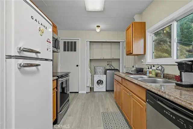 a kitchen with stainless steel appliances granite countertop a sink and a refrigerator