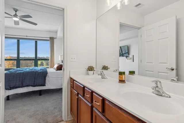 a bathroom with a double vanity sink a mirror and a bathtub