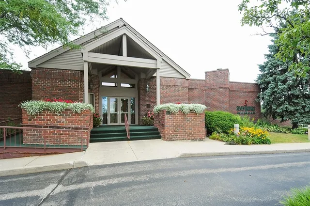 a view of a building with a yard and plants