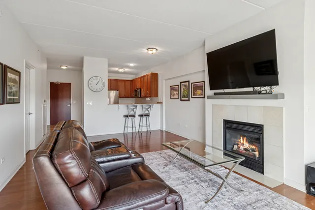 a living room with furniture a flat screen tv and a fireplace