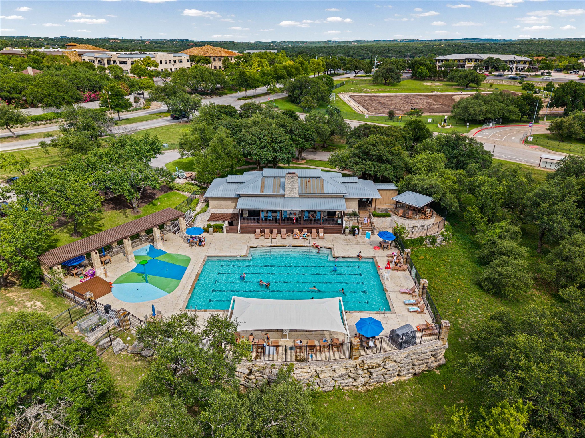 10700 Pointe View Drive Austin, TX 78738 - Photo 31 of 35 An aerial perspective reveals a vibrant community hub with a spacious swimming pool and adjacent splash pad.