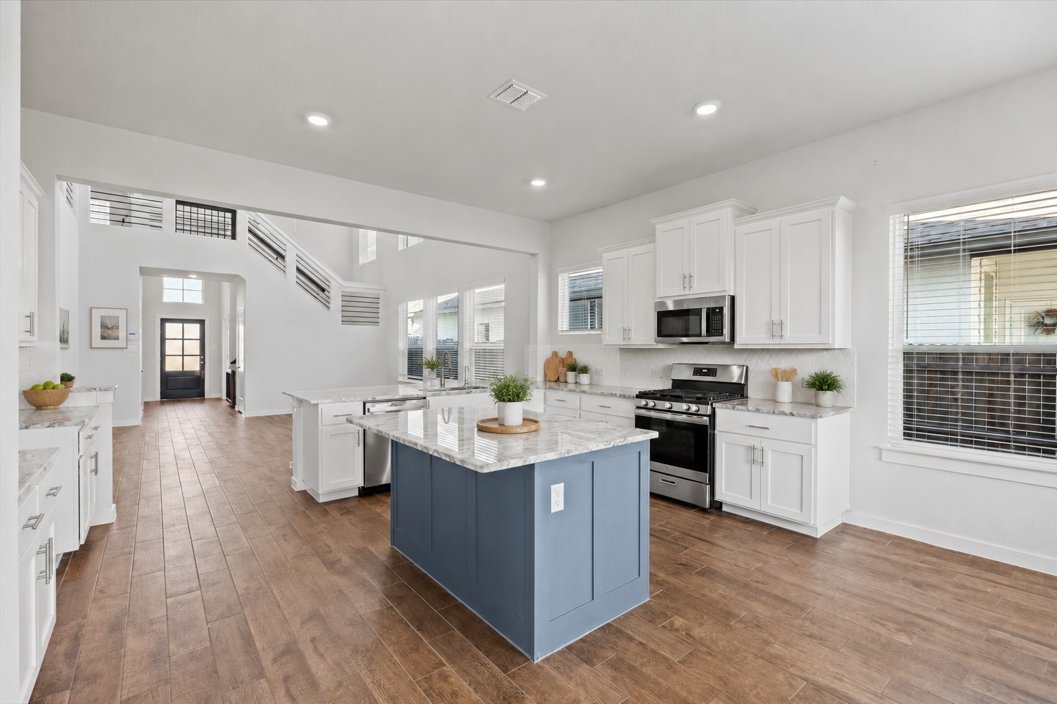 1027 Haystack New Braunfels, TX 78130 - Photo 5 of 15 A grand, open-concept kitchen with a large center island flows seamlessly into the entry foyer.